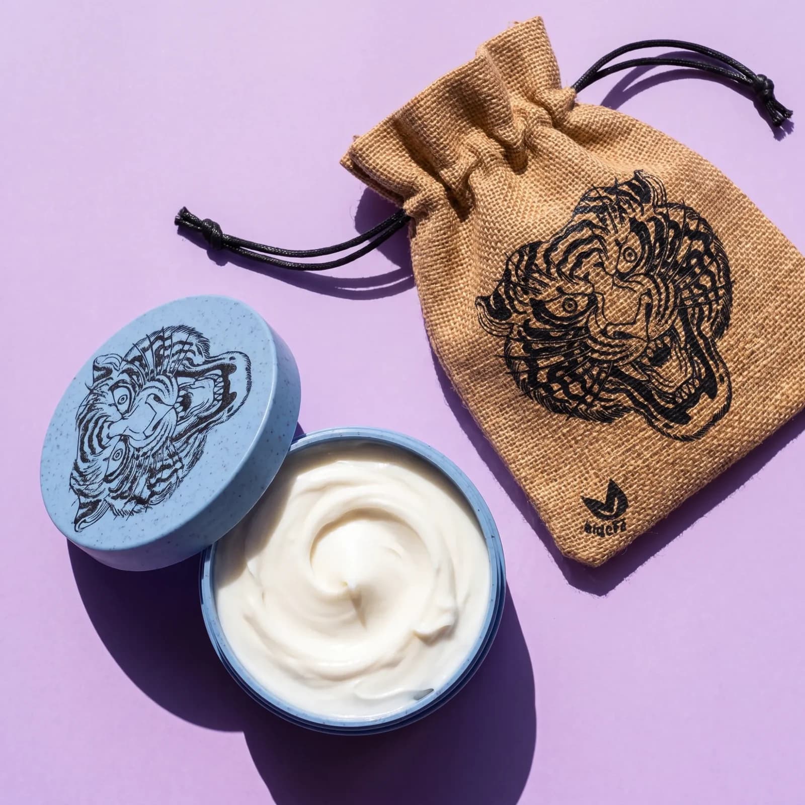 VITIUM Tattoo Butter open beside its tiger lid and drawstring bag, from above